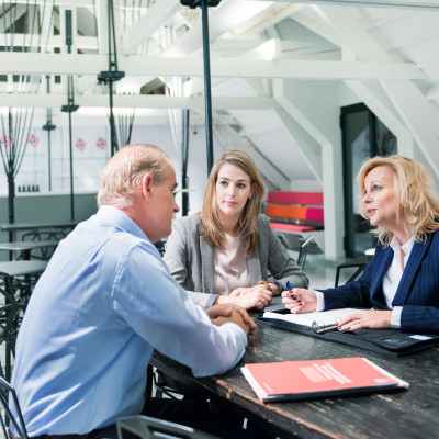 Ondernemer en kind in gesprek met adviseur over bedrijfsoverdracht