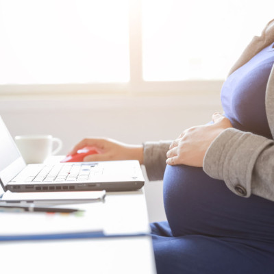 Zwangere vrouw aan het werk achter laptop