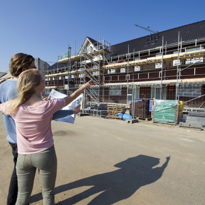 Twee mensen bekijken een huis in aanbouw